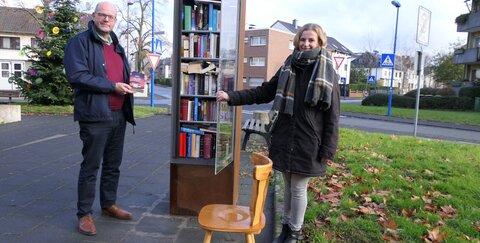 Bildunterschrift: Sandra Stein vom Kulturamt und Beigeordneter Horst Wende am neuen Bücherschrank in Oberlar.