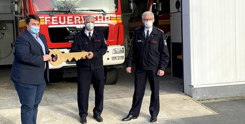 Symbolischer Schlüssel zur provisorischen Feuerwehrhalle: v.l. Bürgermeister Alexander Biber, Löschgruppenführer Salvatore Rizzello und Feurwehrleiter Stefan Gandelau.