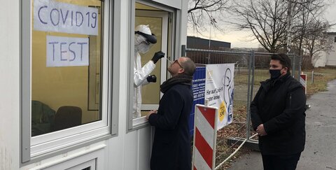Troisdorfs Bürgermeister Alexander Biber (rechts) schaut dabei zu, wie Andreas Hinkel, Geschäftsführer der Eurofins Genomics Europe Sequencing GmbH, sich an Troisdorfs erstem Drive-in für Corona-Schnelltests testen lässt.