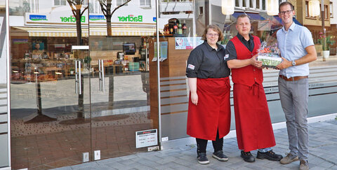 TROWISTA-Wirtschaftsförderer Fabian Wagner (rechts) überreichte das Troisdorfer Willkommenspaket an Filialleiter Pawel Obnolsky und seine Mitarbeiterin Daniela Krause-Wegner.