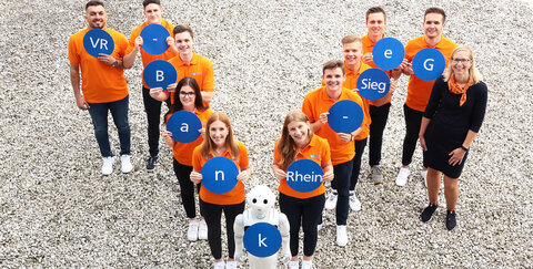 v. l.: Namir Al Jubouri, Andre Lindenberg, Yannic Kleinwächter, Michelle Feist, Pia Steimer, Pepper, Kaya Bawej, Philipp Marx, Sascha Timm, David Büscher, Nando Sedlag und Ausbildungsleiterin Sabrina Kochanek.